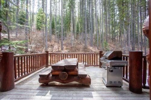 a grill on a wooden deck with a forest at Ravenwood Cabin by StayIn in Panorama