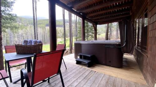 a screened in porch with a table and a grill at Ravenwood Cabin by StayIn in Panorama