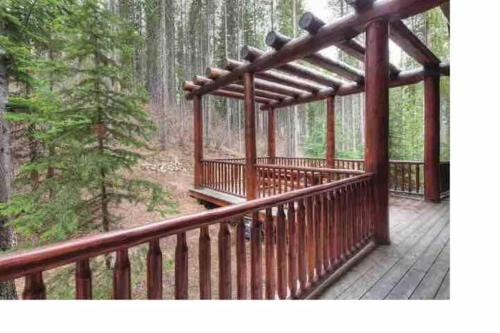 a wooden deck in the middle of a forest at Ravenwood Cabin by StayIn in Panorama