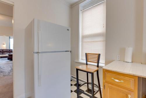 a kitchen with a refrigerator and a wooden stool at 9 Mi to Downtown St Louis Apt with Fire Pit Access in Bella Villa