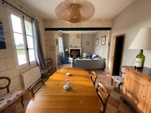 a living room with a wooden table and a couch at Gite de La Providence in Ludon-Médoc