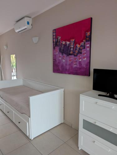 a white bedroom with a bed and a tv at Slowliday in Viverone