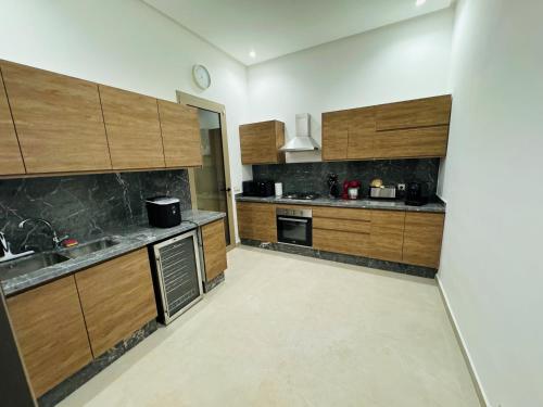 a large kitchen with wooden cabinets and appliances at Villa Palms de l'Atlas in Marrakech