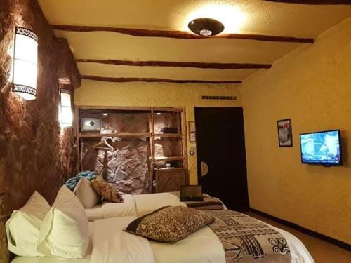 ein Schlafzimmer mit zwei Betten und einem Fernseher darin in der Unterkunft Marruecos Excursiones in Inezgane