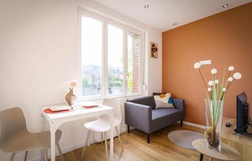 un salon avec une table et une chaise dans l'établissement Appartement Royal séjour, Parking gratuit, à Saint-Quentin