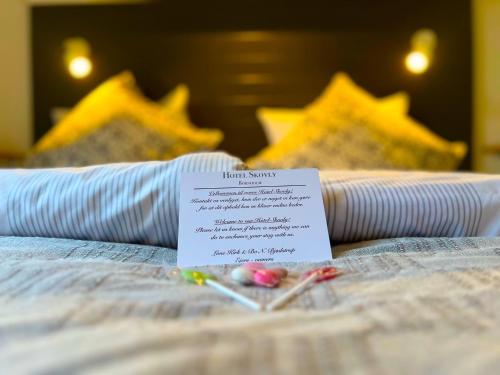 a sign sitting on top of a bed at Hotel Skovly in Rønne