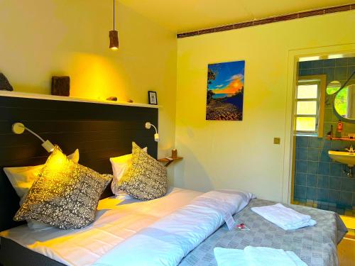 a bedroom with a bed with pillows on it at Hotel Skovly in Rønne