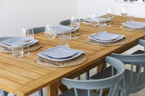 a wooden table with plates and wine glasses on it at Casa Blue Marlin in Kralendijk