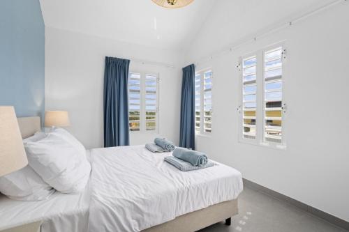 a bedroom with a bed with two towels on it at Casa Blue Marlin in Kralendijk