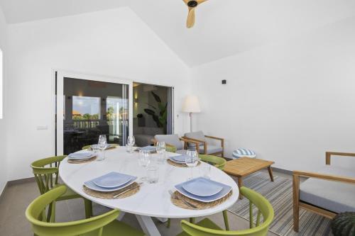 a dining room with a white table and green chairs at Casa Blue Marlin in Kralendijk