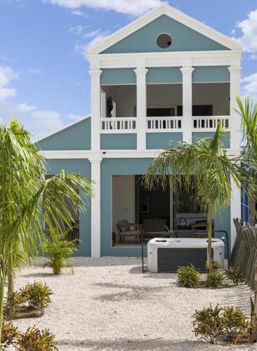 a blue and white house with palm trees in front of it at Casa Blue Marlin in Kralendijk