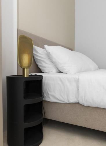 a bed with a black end table with a lamp on it at Casa Blue Marlin in Kralendijk
