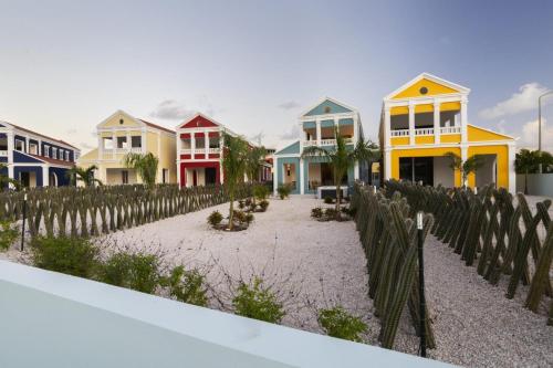 a row of colorful houses behind a wooden fence at Casa Blue Marlin in Kralendijk