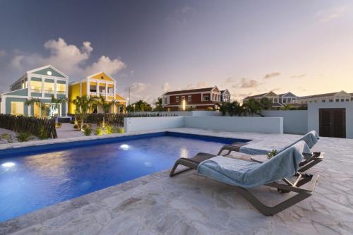 a villa with a swimming pool with a chaise lounge at Casa Blue Marlin in Kralendijk
