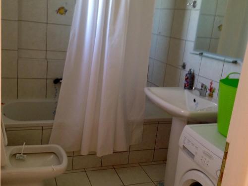 a bathroom with a shower curtain and a sink at Boutique Hotel Ileas Village in Arkoudi