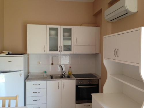 a small kitchen with white cabinets and a sink at Boutique Hotel Ileas Village in Arkoudi
