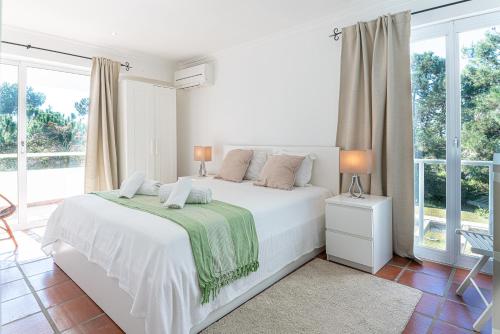 una camera bianca con letto bianco e finestre di Villa Yara a Tróia