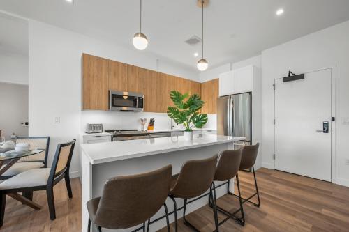 a kitchen with a bar with chairs and a table at Luxury Furnished Apartment Near Logan Airport in Boston