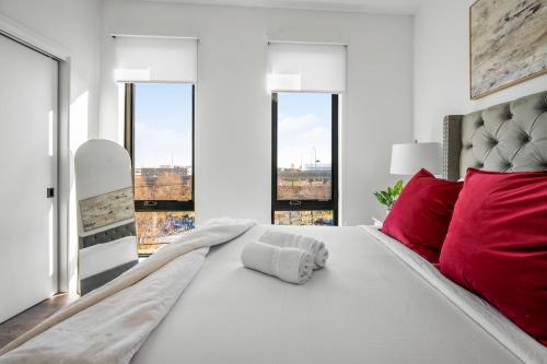 a bedroom with a large white bed with red pillows at Luxury Furnished Apartment Near Logan Airport in Boston