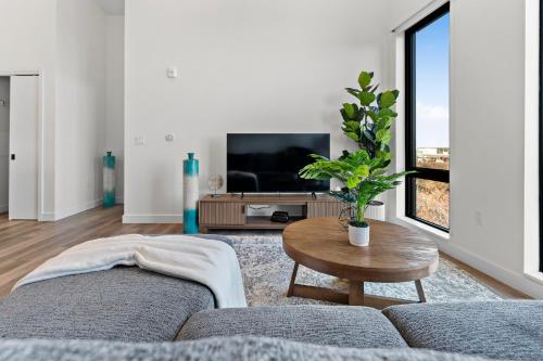 a living room with a couch and a table and a tv at Luxury Furnished Apartment Near Logan Airport in Boston
