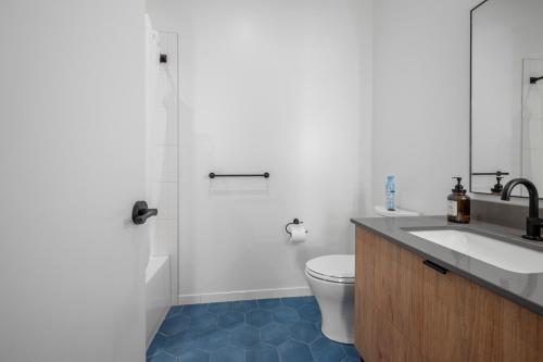 a bathroom with a sink and a toilet and a shower at Luxury Furnished Apartment Near Logan Airport in Boston