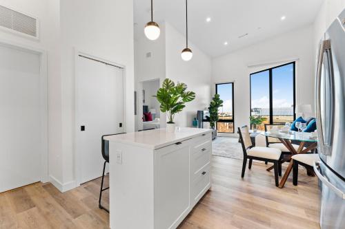 a kitchen with white cabinets and a dining room with a table at Luxury Furnished Apartment Near Logan Airport in Boston
