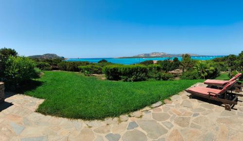 a park with a bench and a view of the ocean at Villa Gino in Stintino