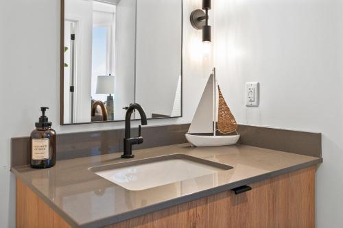 a bathroom counter with a sink and a mirror at Luxury Furnished Apartment Near Logan Airport in Boston