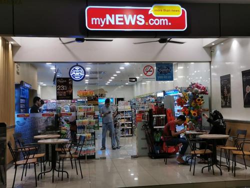 a store with people sitting at tables in a store at Vista Alam 3 bedroom in Shah Alam