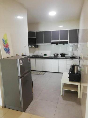 a kitchen with white cabinets and a stainless steel refrigerator at Vista Alam 3 bedroom in Shah Alam