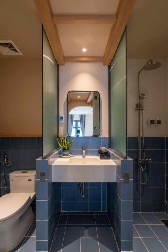 a bathroom with a sink and a toilet and a mirror at DP Hotel in Tây Ninh