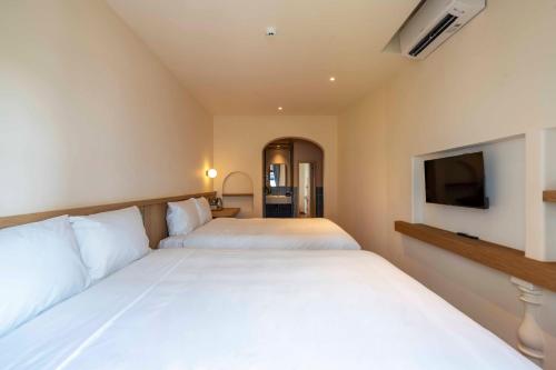 a bedroom with two beds and a flat screen tv at DP Hotel in Tây Ninh