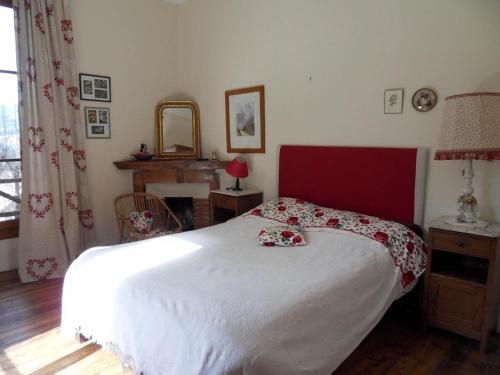 a bedroom with a white bed with a red headboard at La Chaumière, Formule maison entière in Colmars