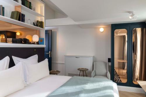 a bedroom with a white bed and a chair at Hotel Louvre Montana in Paris