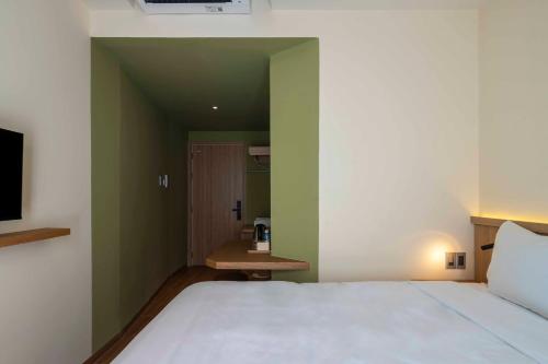 a bedroom with a white bed and green walls at DP Hotel in Tây Ninh