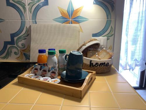a kitchen counter with a tray of food and bottles of juice at Les Petites Maisons in Rodi Garganico