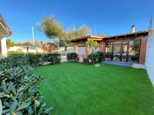 een tuin met een groot gazon voor een huis bij Casa vacanze Ciachea Home - con BBQ , Parcheggio gratuito , A 10 min Da Palermo & Aeroporto in Carini