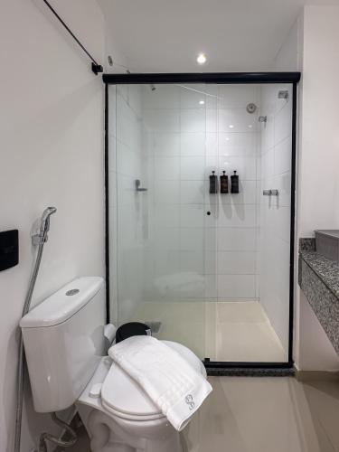 a white bathroom with a shower and a toilet at Suíte Pátio Paulista 1404 in Sao Paulo