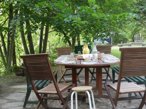 a wooden table with chairs and a table with glasses at La Chaumière, Formule maison entière in Colmars