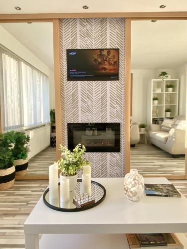 a living room with a fireplace and a tv on a wall at Seaview Cottage on the Island in Millbay