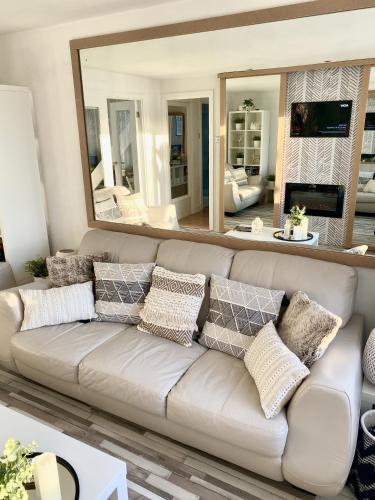 a living room with a couch and a large mirror at Seaview Cottage on the Island in Millbay