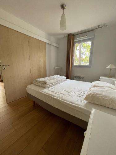 une chambre avec un grand lit et une fenêtre dans l'établissement Appartement T3 au Bord du Lac, à Parentis-en-Born