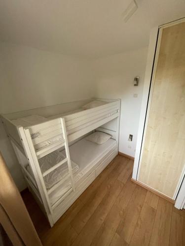 Cette petite chambre comprend des lits superposés blancs. dans l'établissement Appartement T3 au Bord du Lac, à Parentis-en-Born