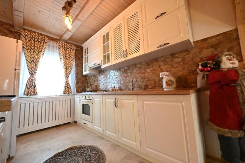 a kitchen with white cabinets and a woman taking a picture at Casa Pop in Râşnov