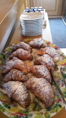 un piatto di ciambelle in polvere, seduto su un tavolo di Villa Mola Bed And Breakfast a Corbara