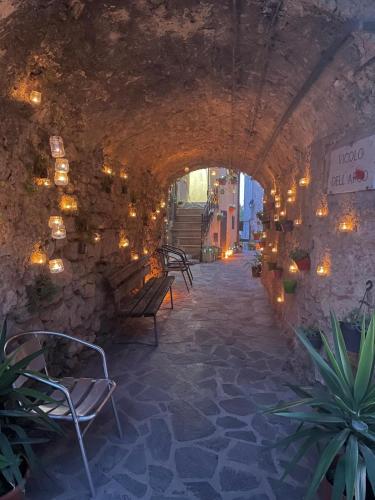 an alley with a stone wall with a bench and lights at La casa in fontana in Cerdomare