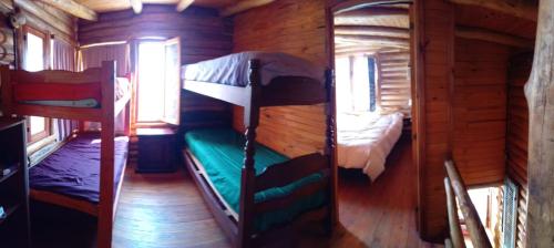 a room with two bunk beds in a log cabin at Cabañas - sierras de cordoba - Jose de la quintana #3 in José de la Quintana