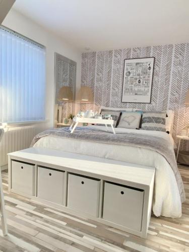 a bedroom with a white bed with a table on it at Seaview Cottage on the Island in Millbay