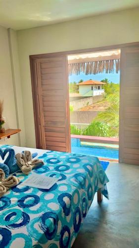 a bedroom with a bed with a view of a pool at Pousada Areias de Flecheiras in Flecheiras