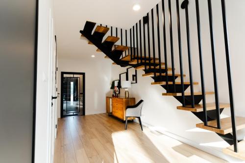 a spiral staircase in a living room with a chair at Flora & Sauna Kamieńczyk Konwaliowa 8 in Błonie